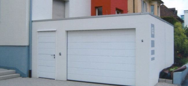 weiße Garage mit Sektionaltor und Seiteneingangstür